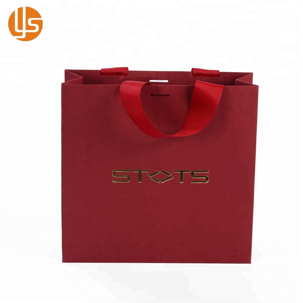 La venta al por mayor de la fabricación de China crea la bolsa de papel hecha a mano de compras de lujo roja que empaqueta la ropa para requisitos particulares