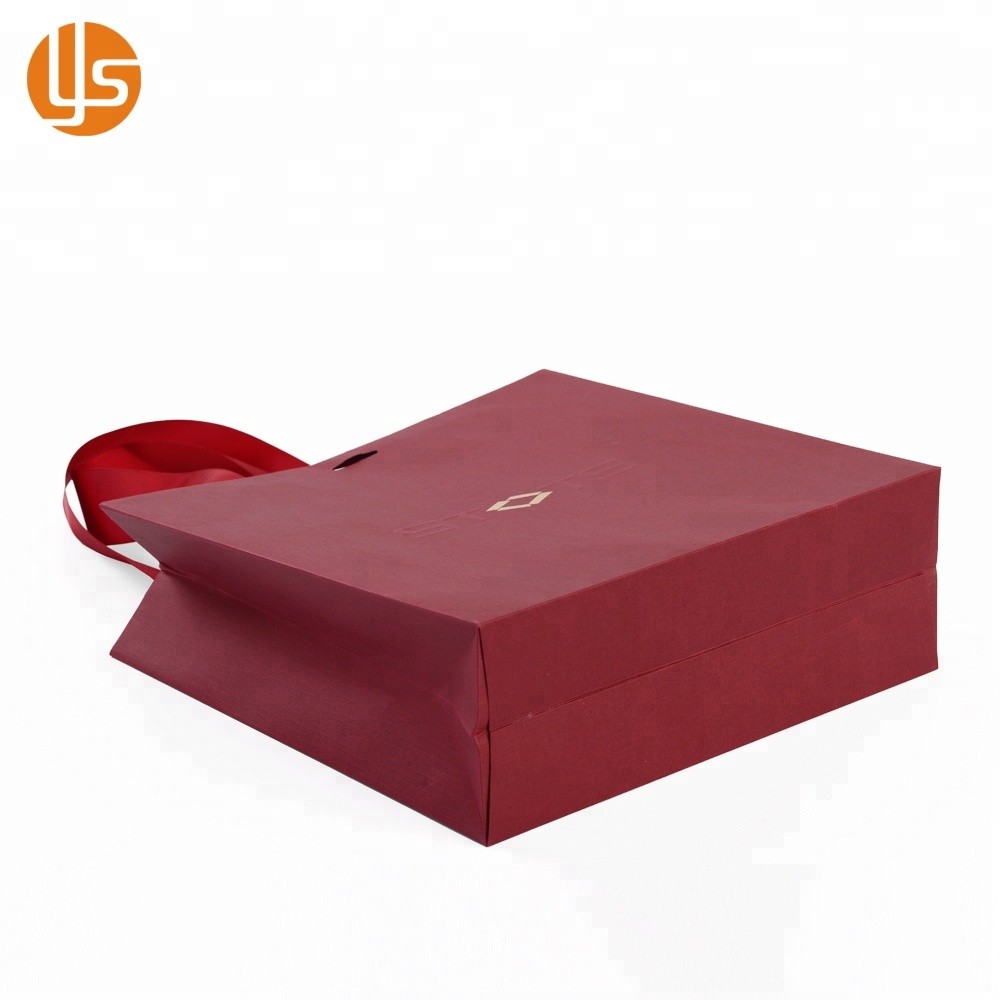 La venta al por mayor de la fabricación de China crea la bolsa de papel hecha a mano de compras de lujo roja que empaqueta la ropa para requisitos particulares